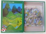 Image of the puzzle 500, Heye, Football Hill, Guillermo Mordillo. Picture of the bag with pieces puzzle.